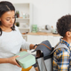 Parent putting lunch box in child's backpack